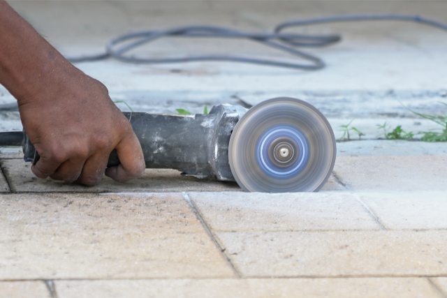 Worker using tiles cutting saw to cut floor tiles